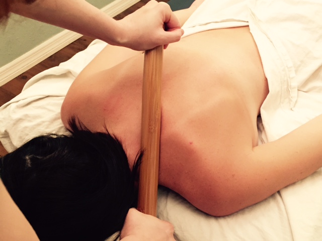 woman enjoys a warm bamboo massage