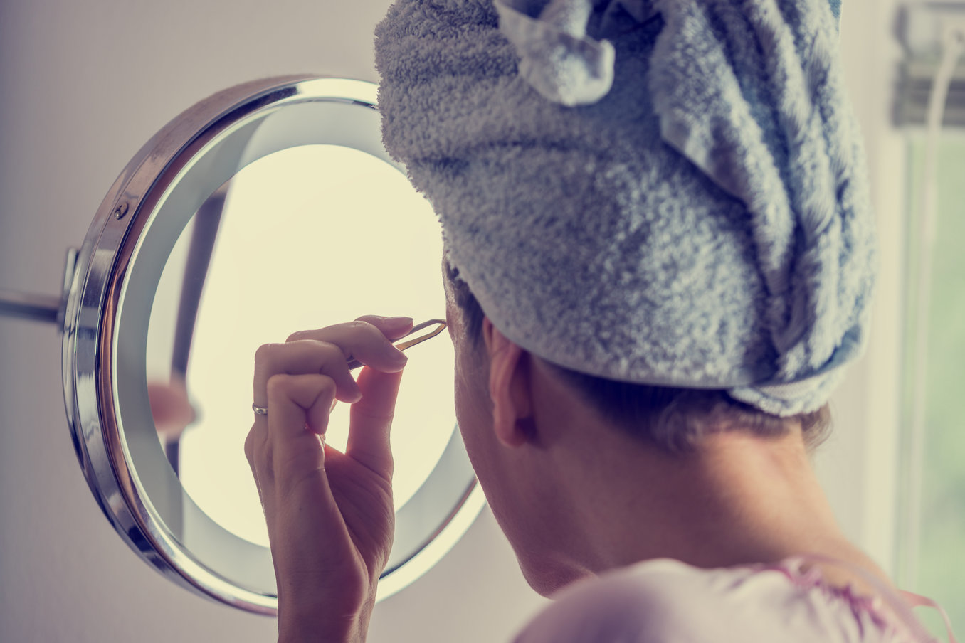 Woman plucking her eyebrows