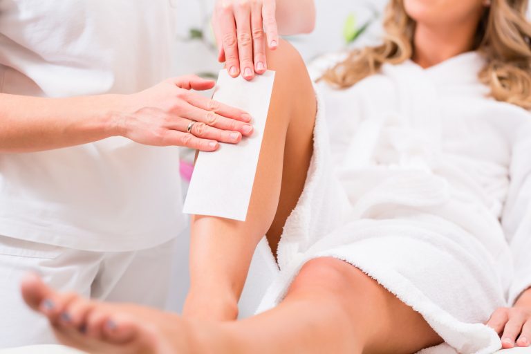 Woman at waxing hair removal in beauty parlor